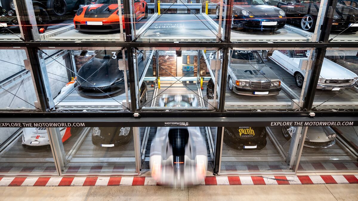 A parking system with several cars neatly lined up against a wall in the museum