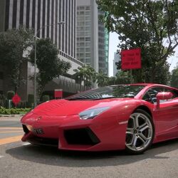A red Ferrari driving down the road into the underground car park