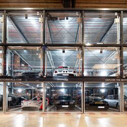Parking system at Motorworld Mallorca, with cars parked in a square formation inside glass boxes