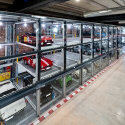 An oblique view of the car park at Motorworld in Mallorca, featuring sports cars in glass display cases