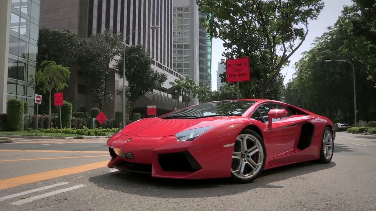 A red Ferrari driving down the road into the underground car park