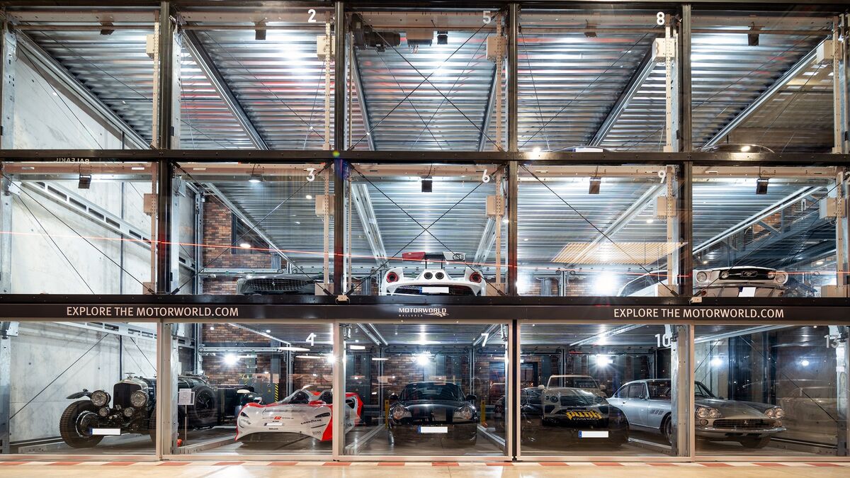 Parking system at Motorworld Mallorca, with cars parked in a square formation inside glass boxes