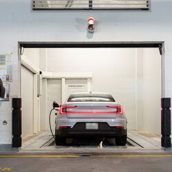 De afbeelding toont de overdrachtsruimte van een geautomatiseerd parkeersysteem, waar de bestuurder het parkeerproces start zodat het voertuig automatisch naar het parkeersysteem wordt verplaatst en geparkeerd.