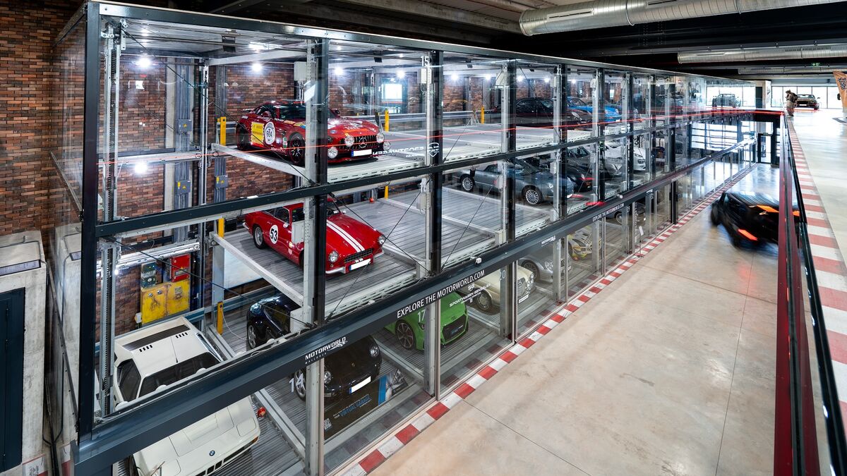 An oblique view of the car park at Motorworld in Mallorca, featuring sports cars in glass display cases